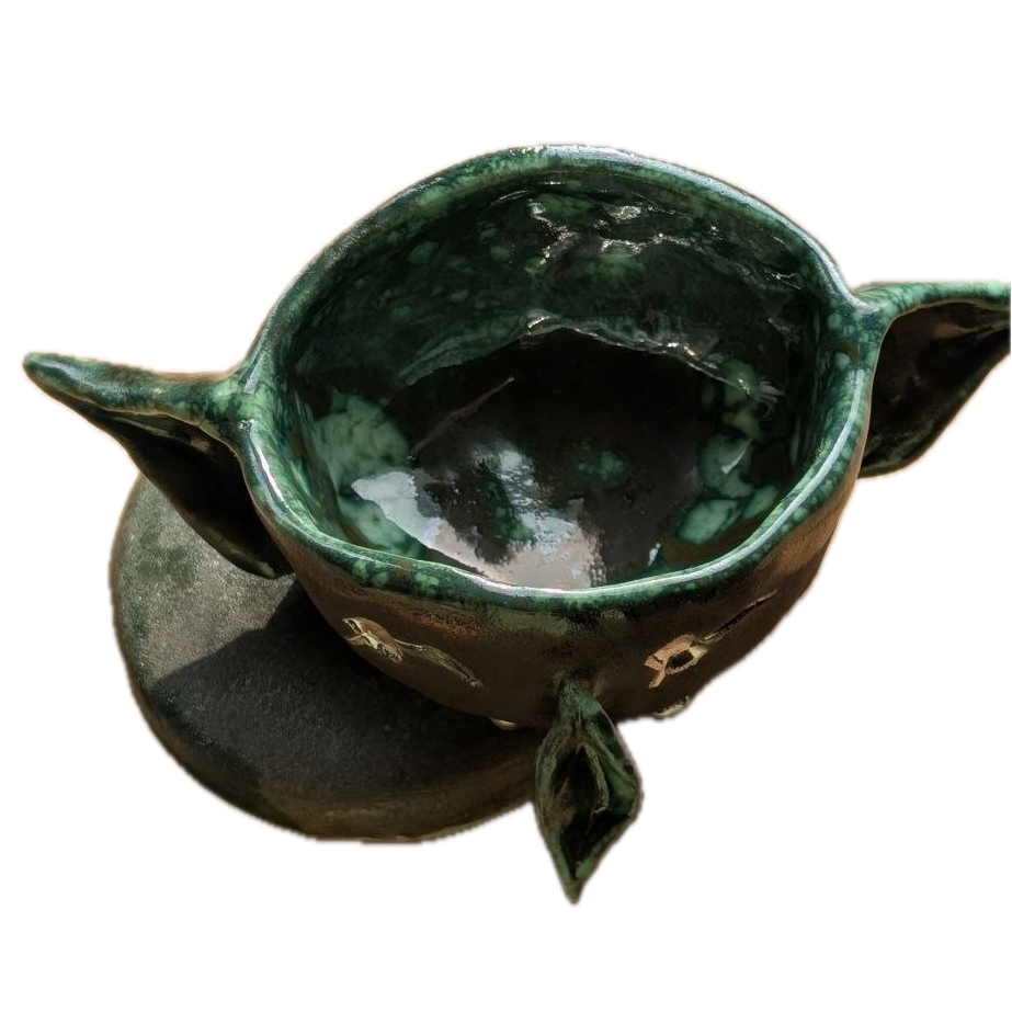 Green ceramic espresso cup with a handle on a white background
